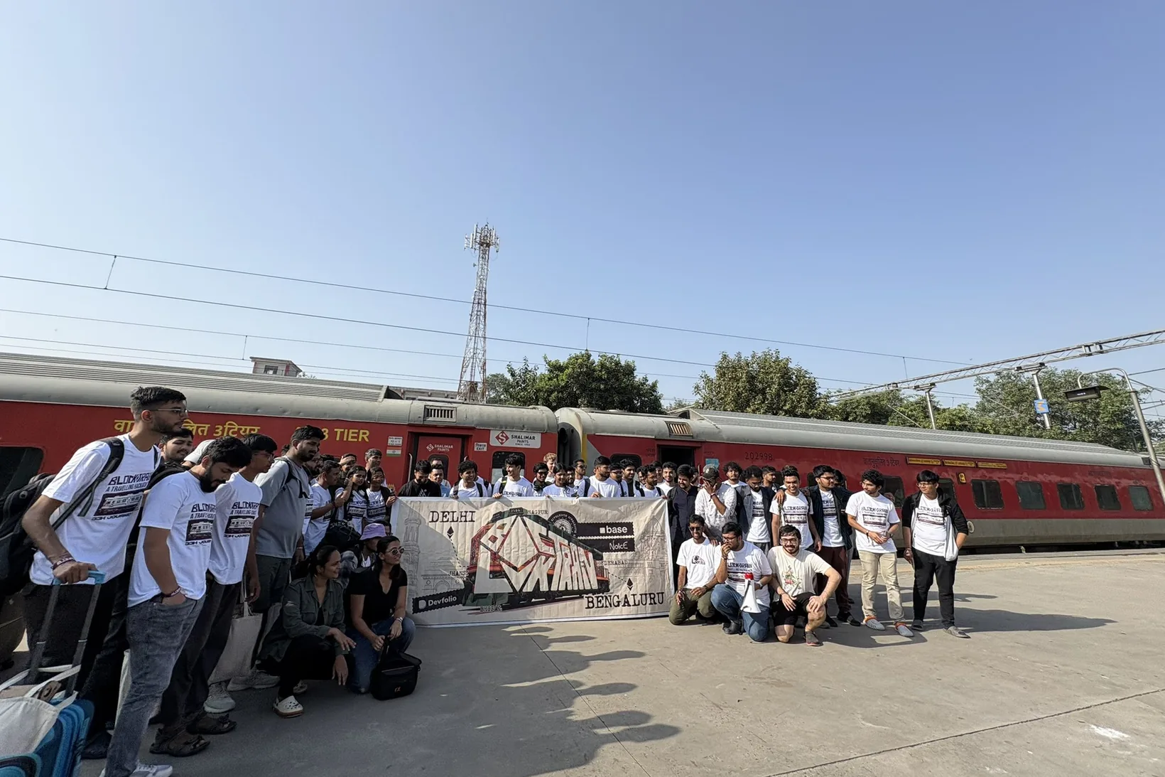 Every Blocktrain hacker lined up on the platform beside the red train, holding the Blocktrain banner