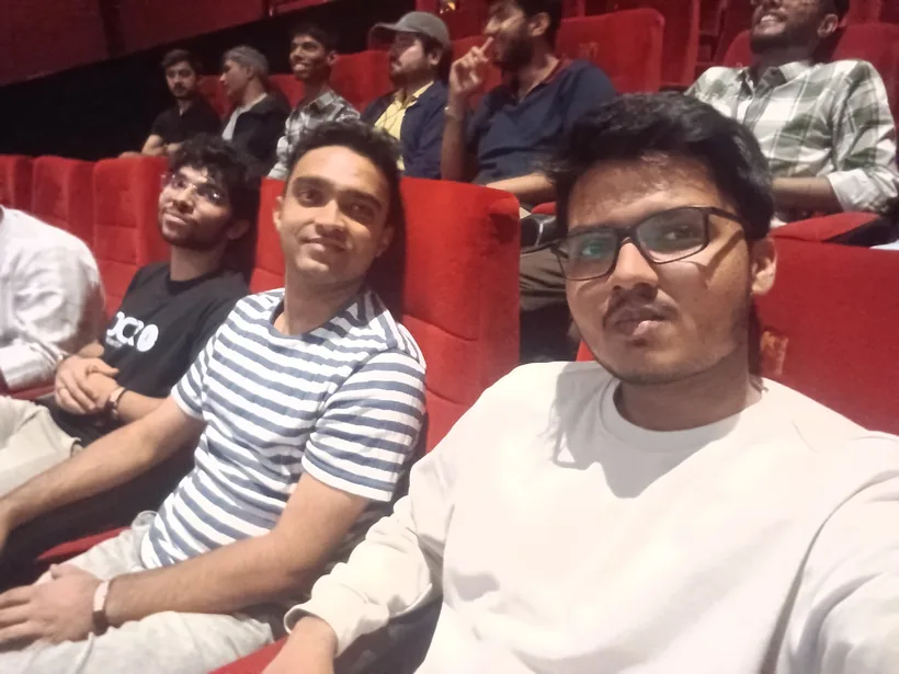 A selfie of Mirza with hackers in red theatre seats at the opening talk