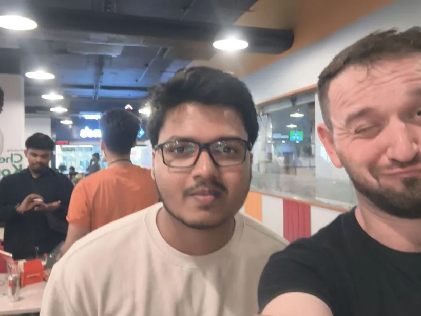 A selfie of Mirza with a grinning hacker in a black T-shirt
