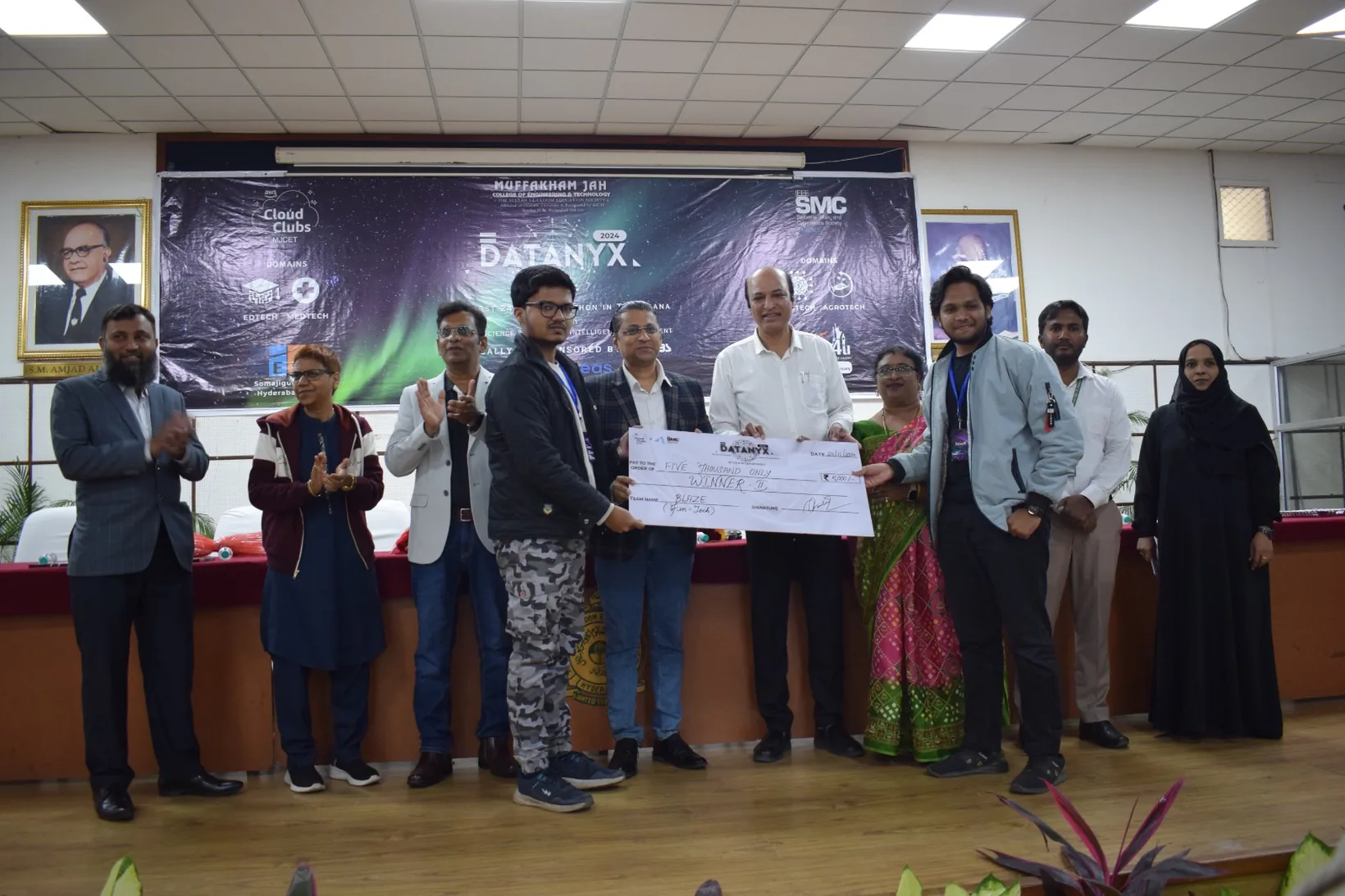Mirza and a teammate on stage receiving the second-place cheque for team Blaze in the fintech domain