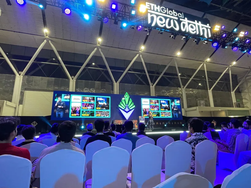 The ETHGlobal New Delhi main stage from the audience, with the peacock logo between two screens