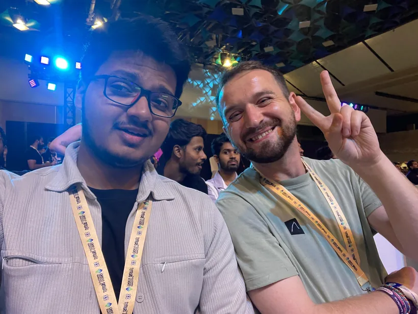 A selfie of Mirza with a smiling attendee making a peace sign