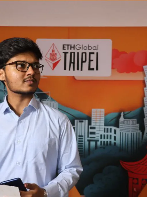 Mirza in a light blue shirt in front of the ETHGlobal Taipei backdrop