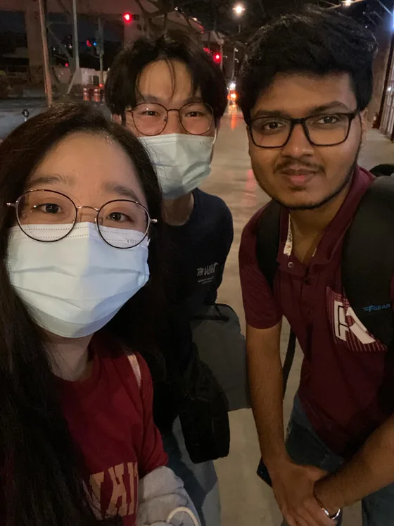 A night-time selfie of Mirza with two friends on a Taipei street