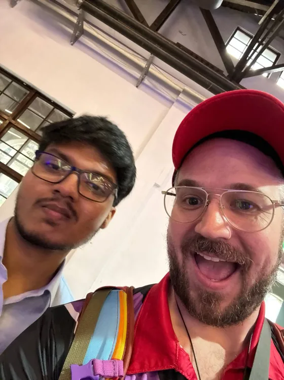 A selfie of Mirza with a laughing attendee in a red cap at the venue