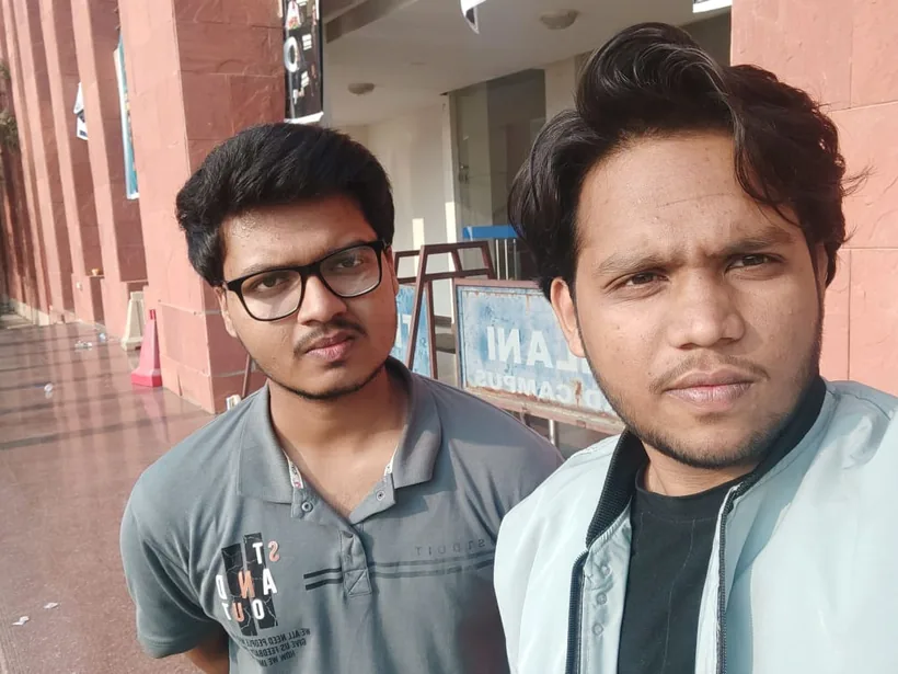 A selfie of Mirza and a teammate outside, by a BITS Pilani sign